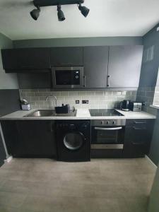 a kitchen with a sink and a washing machine at Central 2 bed apartment in Wolverhampton