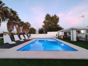 basen na podwórku z krzesłami i domem w obiekcie Apartamento 2, Chalet Manzano a 15" de Sevilla, a 30" del Aeropuerto de Sevilla w mieście Villanueva del Ariscal