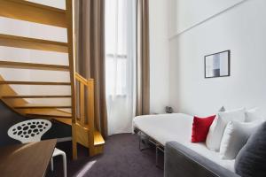 ナントにあるSure Hotel by Best Western Nantes Beaujoireのベッドとソファ付きのホテルルーム