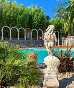 a statue of a mermaid in front of a pool at Castello di Pandora in Nepi