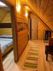 シェレゲシュにあるChalet on Svobodnaya streetの木造キャビン内のベッド1台が備わるベッドルーム1室を利用します。