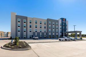 un gran edificio con coches estacionados en un estacionamiento en Comfort Inn & Suites Balch Springs - SE Dallas en Balch Springs