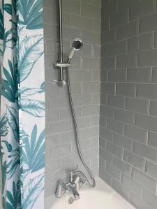 a shower with a shower head in a bathroom at Grace Stays in Ellesmere Port