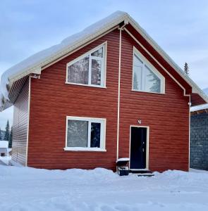 シェレゲシュにあるChalet Lesnie Dolinyの雪の青い扉のある赤い家
