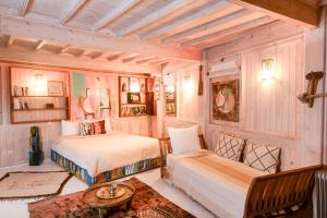 a bedroom with two beds and a bench in it at Dar Cherazade & spa in Essaouira