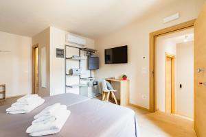 1 dormitorio con cama blanca y escritorio en Guest House La Sosta en Solighetto