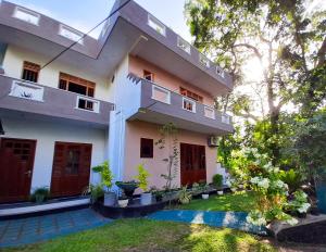 a house with a balcony and a yard at Halcyon Rest in Hikkaduwa