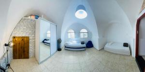 a large white room with a mirror and a bed at Zimmer in old City in Safed