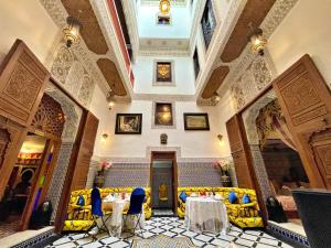 a room with tables and chairs in a building at Riad Dar Guennoun in Fès