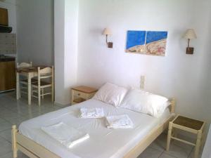 a white bed with two pillows on it in a room at Aeolos Hotel Apartments in Gythio