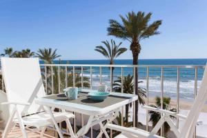 シッチェスにあるSitges Bellavista Vistas Espectaculares del Marのビーチ付きのバルコニー(テーブル、椅子付)