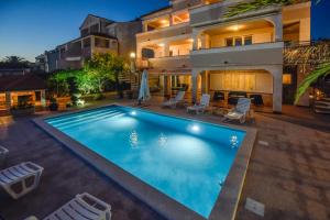 une piscine dans l'arrière-cour d'une maison dans l'établissement Beachfront Apartments Tolo with Pool, à Novalja