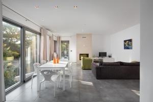 a living room with a white table and a couch at Villa Valsavia-apartment Monsena with pool and SPA in Rovinj