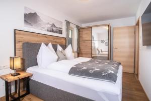 ヴィージングにあるApart Dahoamのベッドルーム(白い大型ベッド1台、木製ヘッドボード付)