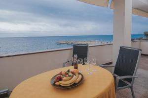 - une table avec une assiette de fruits et des verres à vin dans l'établissement Beachfront Apartments Tolo with Pool, à Novalja 23 autres photos