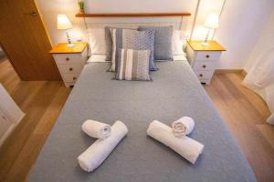 a large bed with towels on it with two night stands at HabitaHost Ramón y Cajal in Cuenca