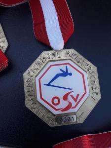 una medalla de plata con un logo de superman en una cinta en Haus-Claudia, en Viehhofen