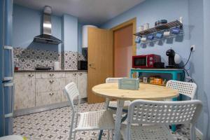 a kitchen with a table and chairs in a kitchen at HabitaHost Ramón y Cajal in Cuenca