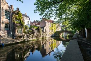 a canal in a city with houses and a bridge at Cornerhouse Level Ten by Romy&Travis in Bruges