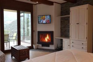 a bedroom with a fireplace and a bedroom with a bed at Refugio Mirador en Casa Rural Camp de Claror in Aixirivall