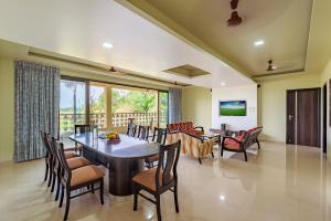 a dining room and living room with a table and chairs at SaffronStays Ocean Breeze, Guhagar in Guhagar