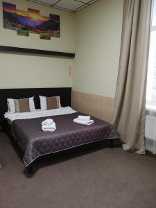um quarto com uma cama com toalhas em Orange Hotel em Lviv