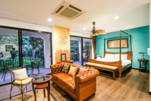 ein Wohnzimmer mit Sofa und Bett in der Unterkunft Rain Tree Khao Yai Hotel in Phayayen + 89 Fotos