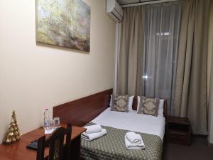 利維夫的住宿－桔子酒店，一间卧室配有一张床、一张桌子和一个窗户。