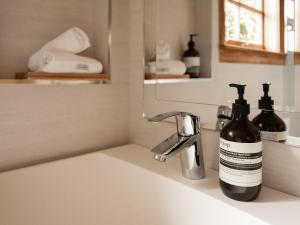 - un lavabo dans la salle de bains avec 2 bouteilles de savon dans l'établissement Cedar Cottage Meander, à Meander 81 autres photos