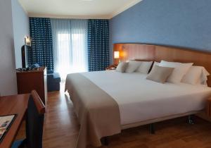 滨海托萨Hotel Delfín的卧室里有一张白色的大床和一扇窗户