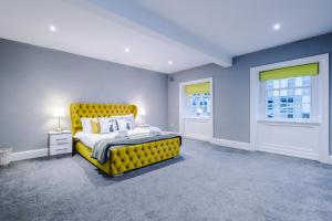 a bedroom with a yellow bed with a yellow headboard at Augustus House in Chester
