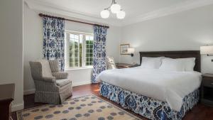 a bedroom with a bed and a chair and a window at Oxford House in Hamilton