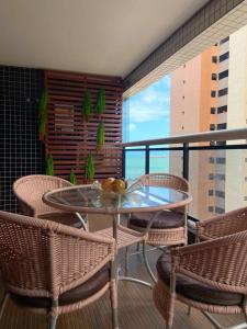 a glass table and chairs on a balcony with a view at Landscape Apartamento Beira Mar 1203TB in Fortaleza