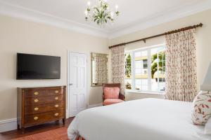 a bedroom with a bed and a tv and a chair at Oxford House in Hamilton