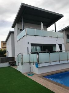 a white house with a swimming pool in front of it at Villa Jupiter con piscina privada in Cambrils