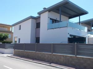 um edifício branco com uma cerca em frente em Villa Jupiter con piscina privada em Cambrils