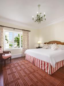 a bedroom with a large bed and a chandelier at Oxford House in Hamilton