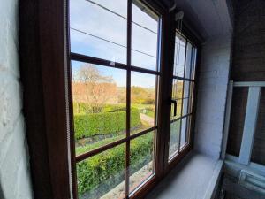 ein offenes Fenster mit Gartenblick in der Unterkunft Au pti fayt in Barbençon