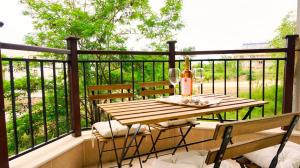 Una mesa y sillas de madera en un balcón. en Бяла Виста Бийч Апартментс B - Byala Vista Beach Apartments B, en Byala 4 fotos más