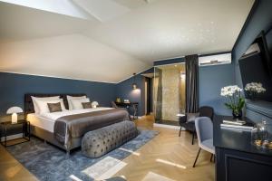a bedroom with blue walls and a bed and a couch at Hotel Imperial - Liburnia in Opatija