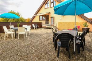 a patio with tables and chairs with blue umbrellas at FeWo Immenstaad 2 in Immenstaad am Bodensee