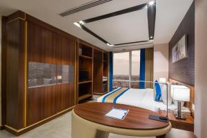 a hotel room with a bed and a desk at Al Malqa Elite Hotel in Riyadh