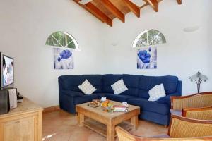 a living room with a blue couch and a table at Luxury Villa in Binibeca with Jacuzzi in Sant Lluis