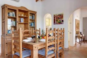 a dining room with a wooden table and chairs at Luxury Villa in Binibeca with Jacuzzi in Sant Lluis