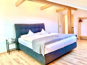 łóżko z niebieskim zagłówkiem w pokoju w obiekcie Fewo Monika Mayr w mieście Pfronten