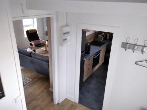 eine Küche und ein Wohnzimmer mit einem blauen Sofa in der Unterkunft Coquelicot in Criquetot-lʼEsneval