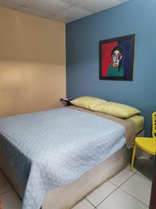 Bett in einem Zimmer mit blauer Wand in der Unterkunft Chambres en Ville in David