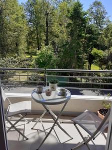 a table and chairs on a balcony with a view at Departamento en Pucón in Pucón +2 photos