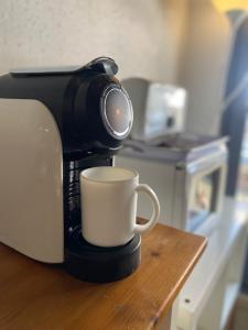- une cafetière avec une tasse sur une table dans l'établissement Neus del Pas, au Pas de la Case