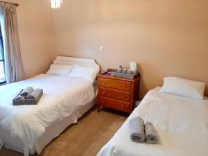two beds in a room with slippers on them at Railway Bar Apartment in Poyntz Pass